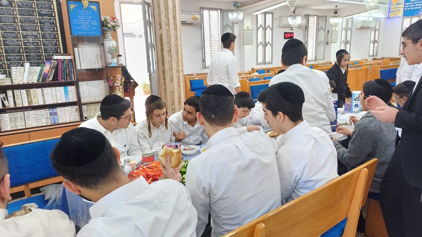 בני הקהילה בסעודה משותפת בבית המדרש של תורה ומוסר בת ים